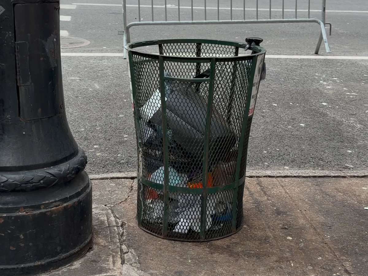 A green mesh trash can